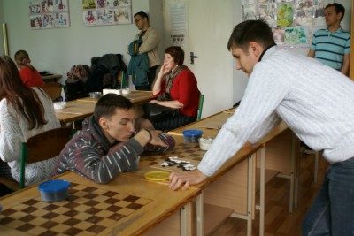 Родители напряженно болеют за своих чад, а посетители турнира устроили битву на маленькой доске